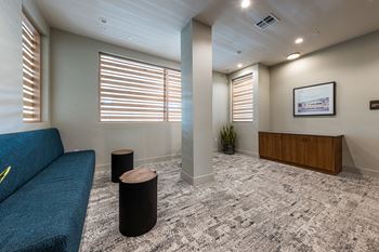 A lobby with a blue couch and a reception desk